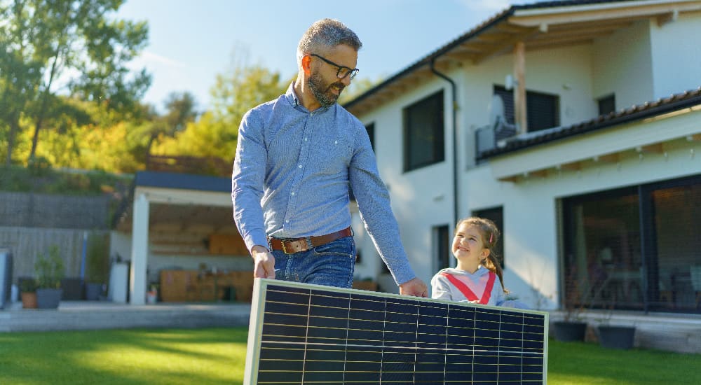 Papá e hija con paneles solares en casa