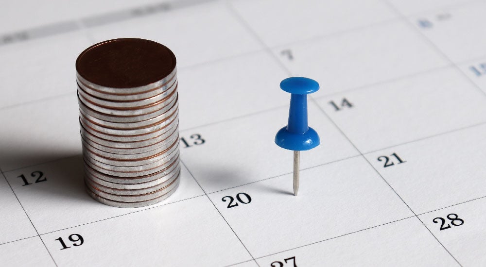 Calendario con target azul y monedas.