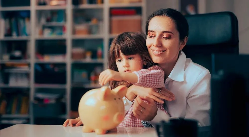 Mamá enseñando a su hija a ahorrar.
