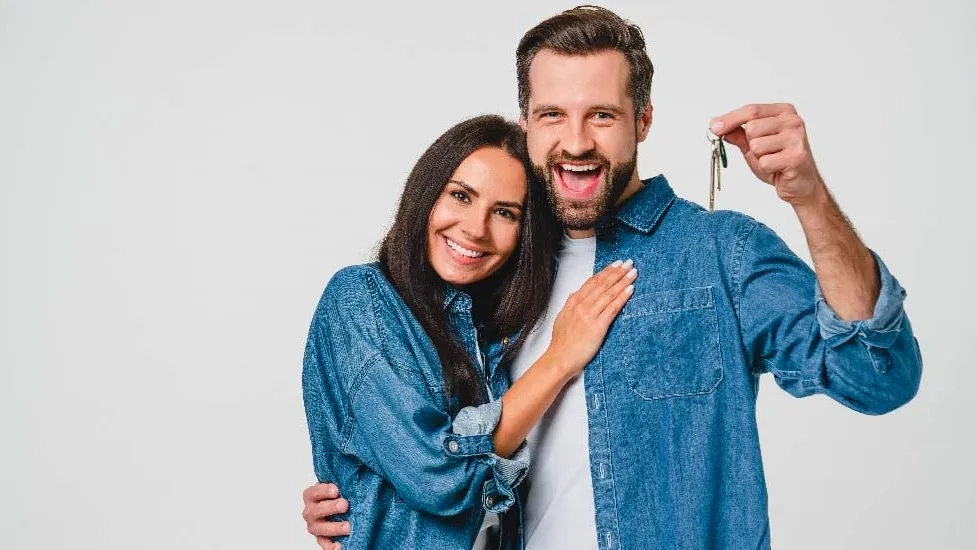 Pareja recibiendo las llaves de su nueva casa.