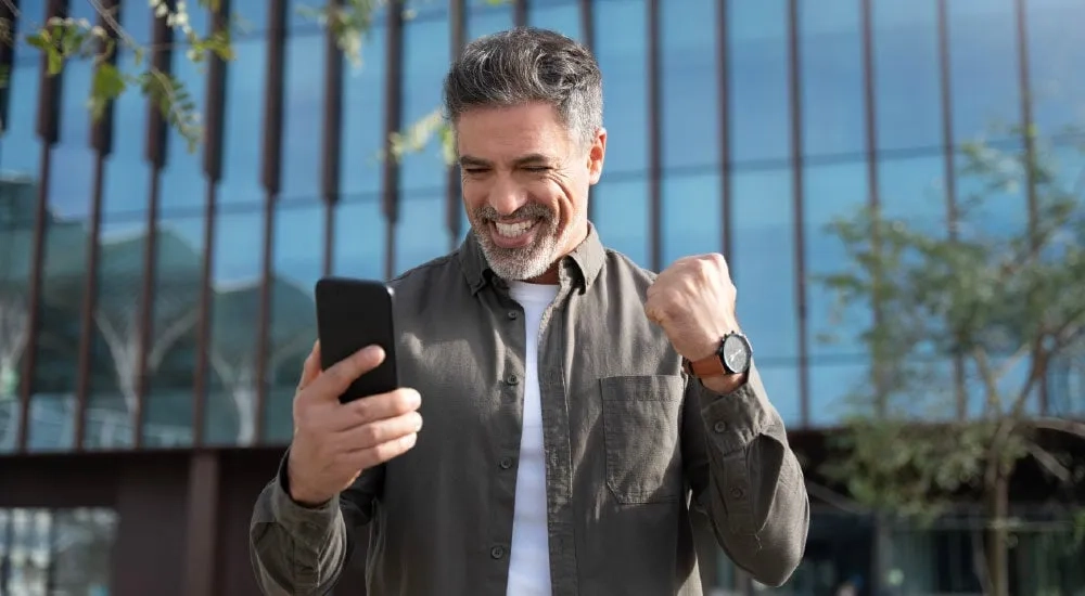 Hombre con celular en mano.