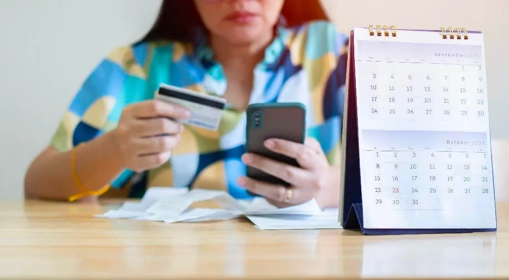 Mujer realizando los pagos de su tarjeta desde el celular.